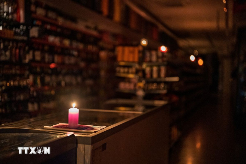 Thắp nến trong cửa hàng ở Barcelona, Tây Ban Nha khi điện bị mất trên diện rộng. (Ảnh: THX/TTXVN)