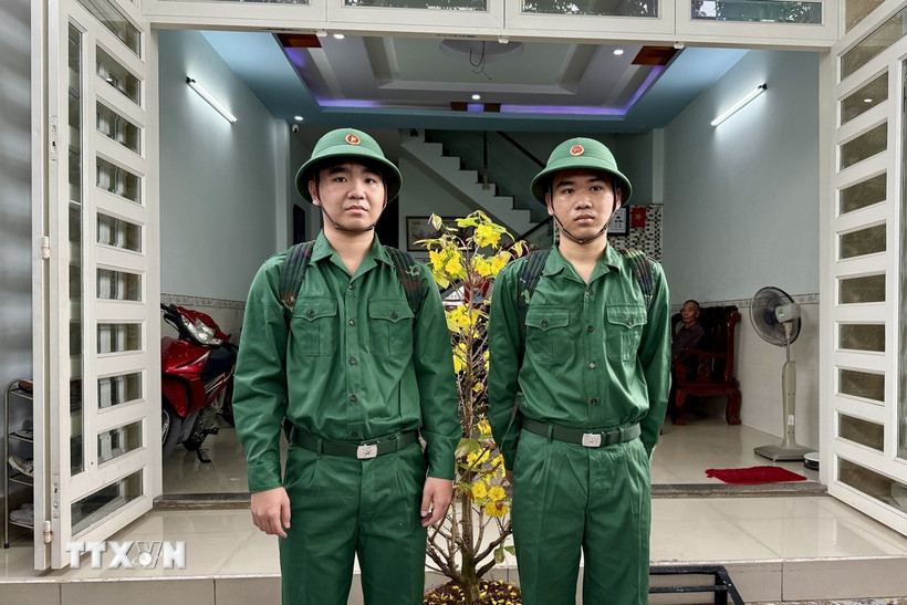 Hai anh em song sinh Hoàng Thế Anh và Hoàng Hải Anh sinh năm 2004, ngụ phường Trảng Dài, thành phố Biên Hoà, Đồng Nai, cùng viết đơn tình nguyện nhập ngũ. (Ảnh: Lê Xuân/TTXVN)