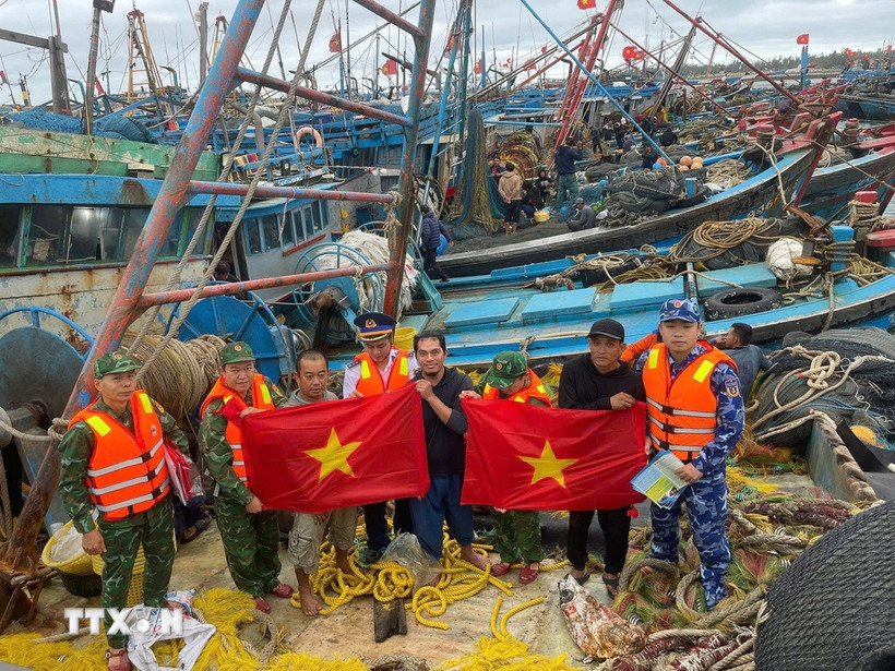 Bộ đội Biên phòng Hải Phòng tặng cờ Tổ quốc cho bà con ngư dân tại âu cảng Bạch Long Vỹ. (Ảnh: TTXVN phát)