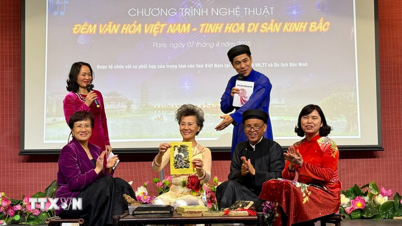 Giới thiệu và trải nghiệm làm tranh Đông Hồ với khán giả. (Ảnh: Nguyễn Thu Hà/TTXVN)