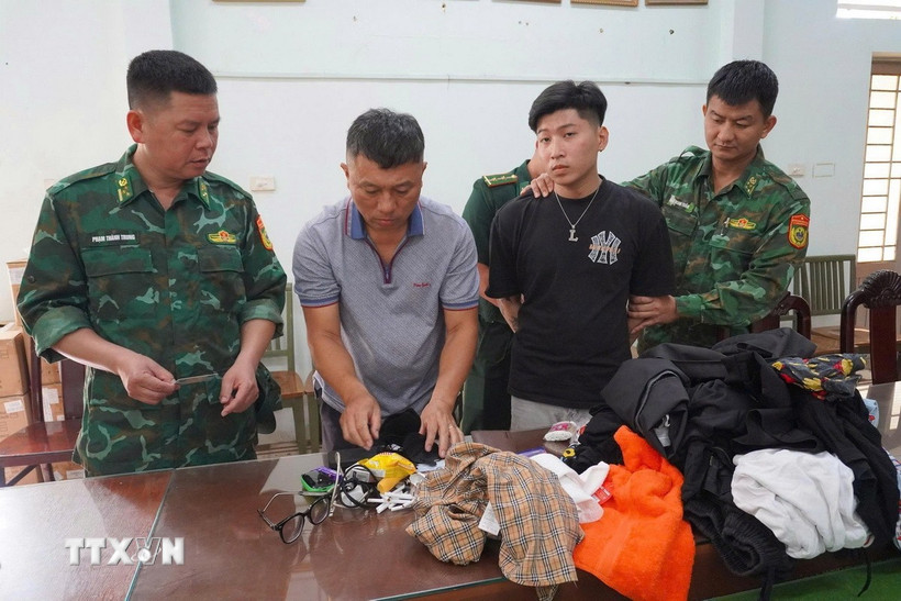 Cán bộ Đồn Biên phòng Mỹ Quý Tây kiểm tra đối tượng cùng tang vật. (Ảnh: TTXVN phát)
