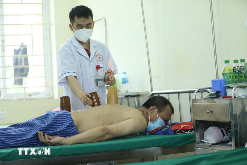 Sử dụng phương pháp giác hơi điều trị cho bệnh nhân. (Ảnh: Anh Tuấn/TTXVN)