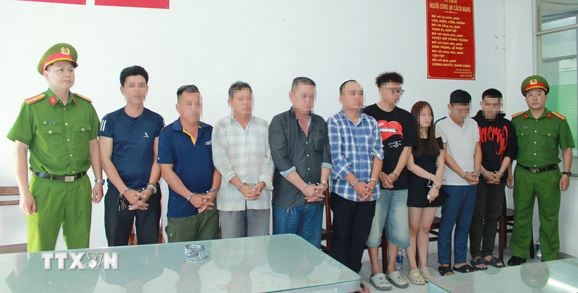 Nhóm 9 người liên quan trong vụ khiêng “quan tài” diễu phố tại Cơ quan điều tra. (Ảnh: TTXVN phát)