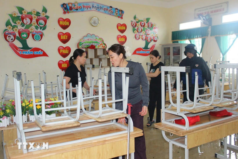 Giáo viên Trường Tiểu học Đỉnh Bàn, xã Thạch Khê, Hà Tĩnh, dọn dẹp trường lớp sau bão. (Ảnh: Hoàng Ngà/TTXVN)