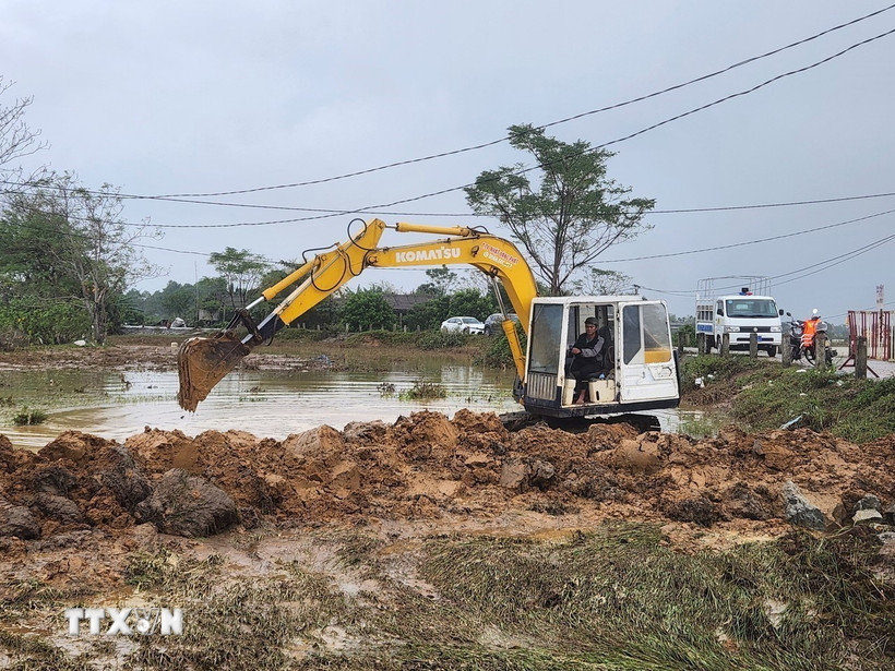 Xe múc được huy động khắc phục đoạn đê bị sạt lở do mưa lũ kéo dài. (Ảnh: Mai Trang/TTXVN)