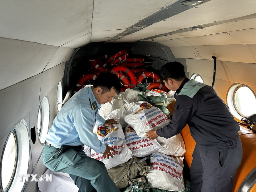 Cán bộ, chiến sỹ Trung đoàn Không quân 930 (Sư đoàn Không quân 372) xếp các bao tải hàng cứu trợ lên máy bay trực thăng để chuyển đến cho người dân đang bị nước lũ bao vây cô lập tại các tỉnh Nam Trung Bộ. (Ảnh: Trần Lê Lâm/TTXVN)