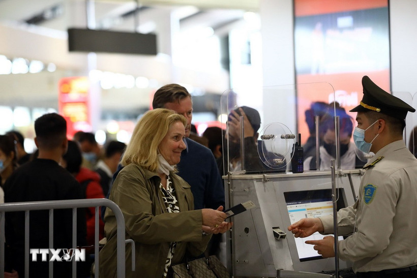 Nhân viên an ninh hàng không kiểm tra thông tin hành khách trước khi vào điểm soi chiếu an ninh. (Ảnh: Huy Hùng/TTXVN)