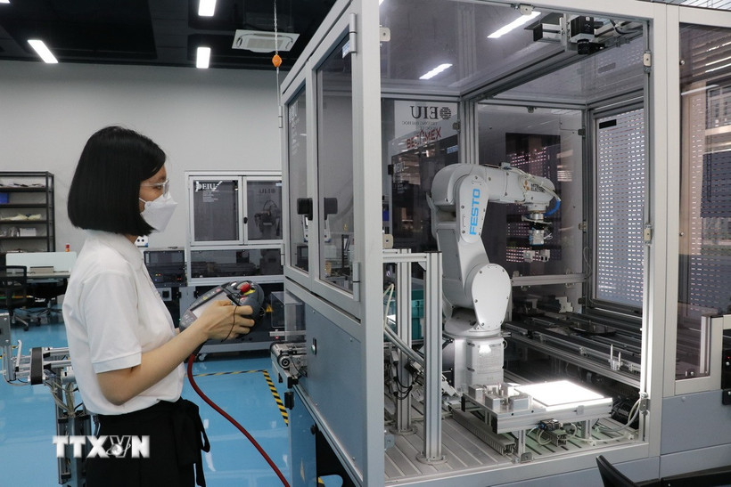Vận hành robot tự động hóa trong sản xuất trong nhà máy để nâng cao năng suất lao động. (Ảnh: Chí Tưởng/TTXVN)