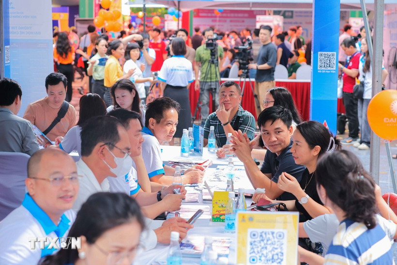 Phụ huynh và thí sinh tìm hiểu thông tin các trường đại học, cao đẳng. (Ảnh: Hoàng Hiếu/TTXVN)