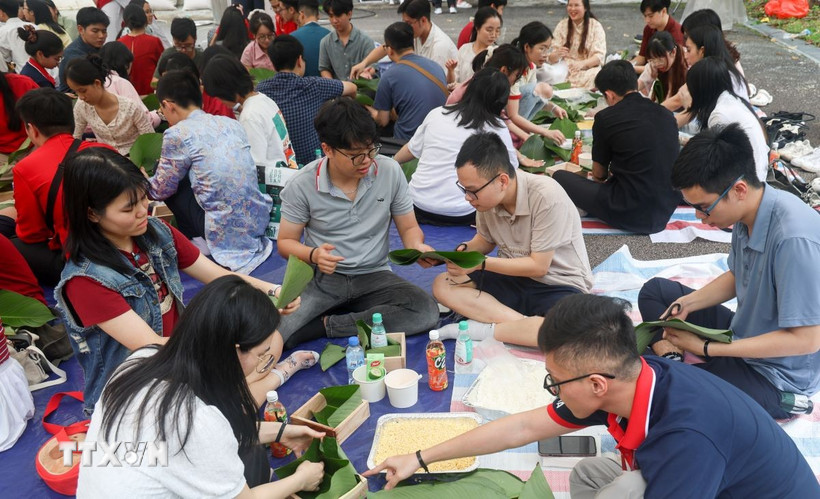 Lưu học sinh thích thú với hoạt động gói bánh chưng chuẩn bị đón Xuân Ất Tỵ. (Ảnh: Ngọc Khương/TTXVN)