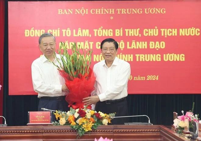 Đồng chí Phan Đình Trạc, Ủy viên Bộ Chính trị, Bí thư Trung ương Đảng, Trưởng Ban Nội chính Trung ương, Phó Trưởng ban Thường trực Ban Chỉ đạo Trung ương về phòng, chống tham nhũng, lãng phí, tiêu cực tặng hoa Tổng Bí thư, Chủ tịch nước Tô Lâm. (Ảnh: Trí Dũng/TTXVN)