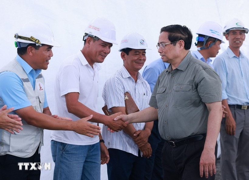 Thủ tướng Phạm Minh Chính với kỹ sư, công nhân thi công Dự án đường bộ cao tốc Châu Đốc-Cần Thơ-Sóc Trăng giai đoạn 1. (Ảnh: Dương Giang/TTXVN)