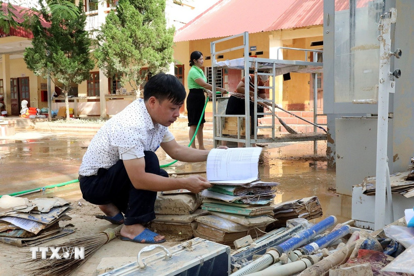 Thầy Hoàng Hữu Dương, Hiệu trưởng Trường Trung học cơ sở xã Yên Bình, tỉnh Lạng Sơn đang xem lại những tài liệu, đồ dùng dạy học nào còn dùng được sẽ cố gắng tận dụng. (Ảnh: Văn Đạt/TTXVN)