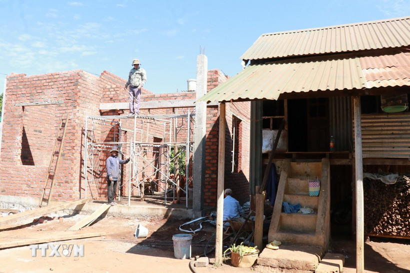 Ngôi nhà mới đang dần được hoàn thiện bên cạnh ngôi nhà cũ của gia đình anh Ksor, hộ nghèo tại làng Mái, xã Ia Hrung (Ia Grai, Gia Lai). (Ảnh: Hồng Điệp/TTXVN)