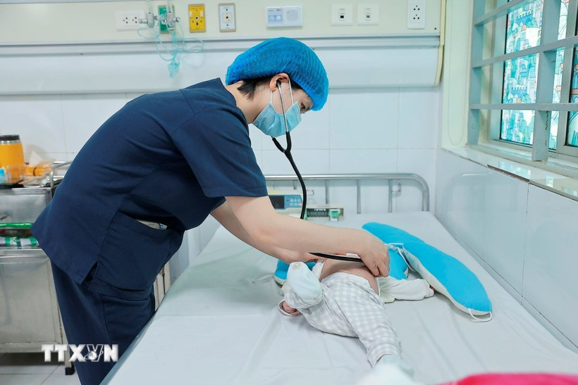 Bác sỹ khám cho bệnh nhi mắc ho gà đang điều trị tại Trung tâm bệnh Nhiệt đới (Bệnh viện Nhi Trung ương). (Ảnh: Minh Quyết/TTXVN)