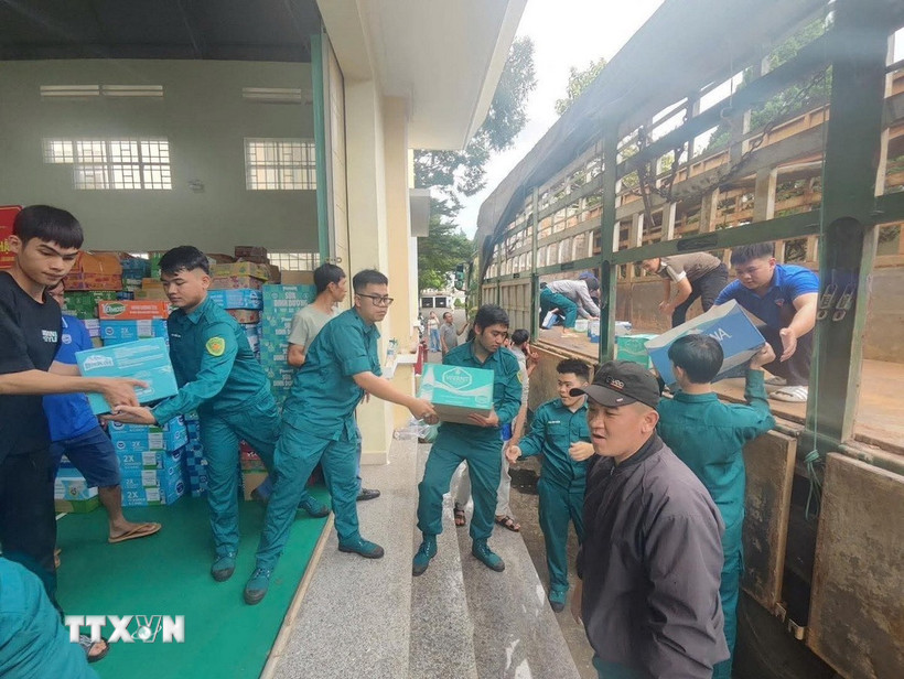 Lực lượng quân đội và nhân dân các xã phía Tây tỉnh Gia Lai sắp xếp hàng hóa gửi về cứu trợ đồng bào lũ lụt. (Ảnh: Hồng Điệp/TTXVN)
