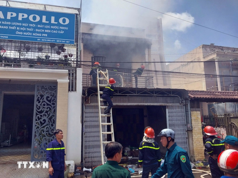 Lực lượng Cảnh sát Phòng cháy chữa cháy và Cứu nạn cứu hộ phải phá cửa tầng 2, dùng vòi phun cao áp dập lửa từ trên xuống. (Ảnh: TTXVN phát)