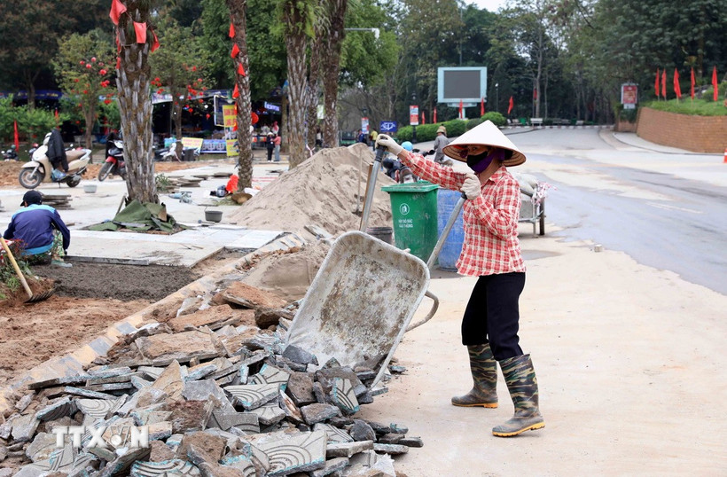 Hệ thống đường vỉa hè trước khu vực đền Giếng được gấp rút hoàn thiện. (Ảnh: Tạ Toàn/TTXVN)
