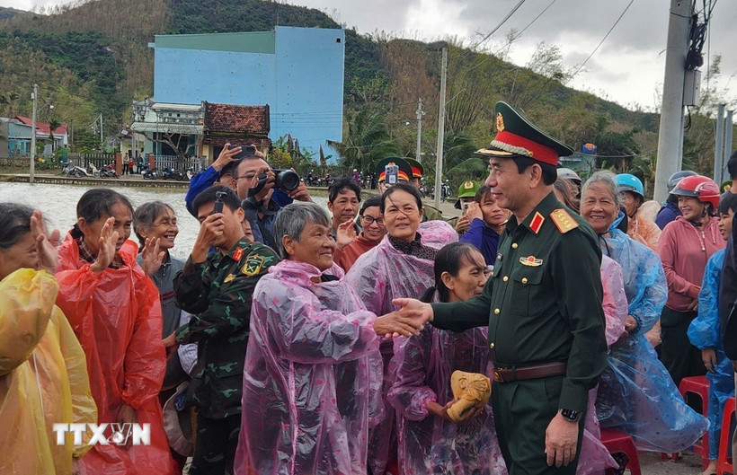 Bộ trưởng Bộ Quốc phòng Đại tướng Phan Văn Giang thăm hỏi người dân vùng lũ ở xã Tuy Phước. (Ảnh: Sỹ Thắng/TTXVN)
