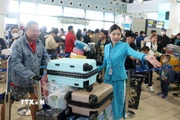 Mặc dù đông nhưng người dân, hành khách vẫn nhận được sự phục vụ, hướng dẫn nhiệt tình từ nhân viên mặt đất. (Ảnh: Quốc Khánh/TTXVN)