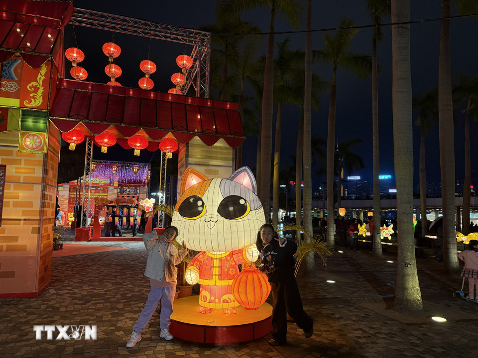 Các em nhỏ tạo dáng chụp cùng đèn lồng. (Ảnh: Mạc Luyện/TTXVN)