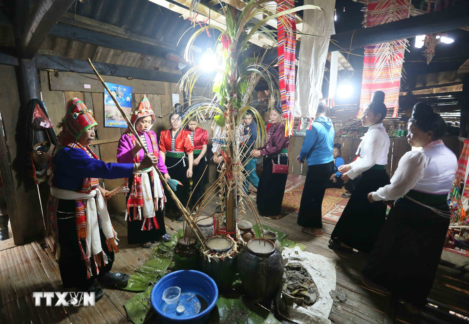Thầy mo đỡ đầu (bên trái) và thầy mo được đỡ đầu thực hiện nghi lễ Mạng Ma. (Ảnh: Quang Quyết/TTXVN)