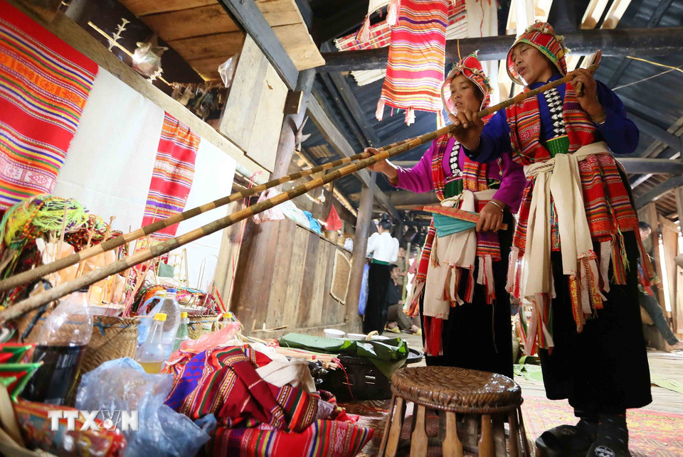 Thầy mo đỡ đầu và thầy mo được đỡ đầu thực hiện nghi lễ Mạng Ma. (Ảnh: Quang Quyết/TTXVN)