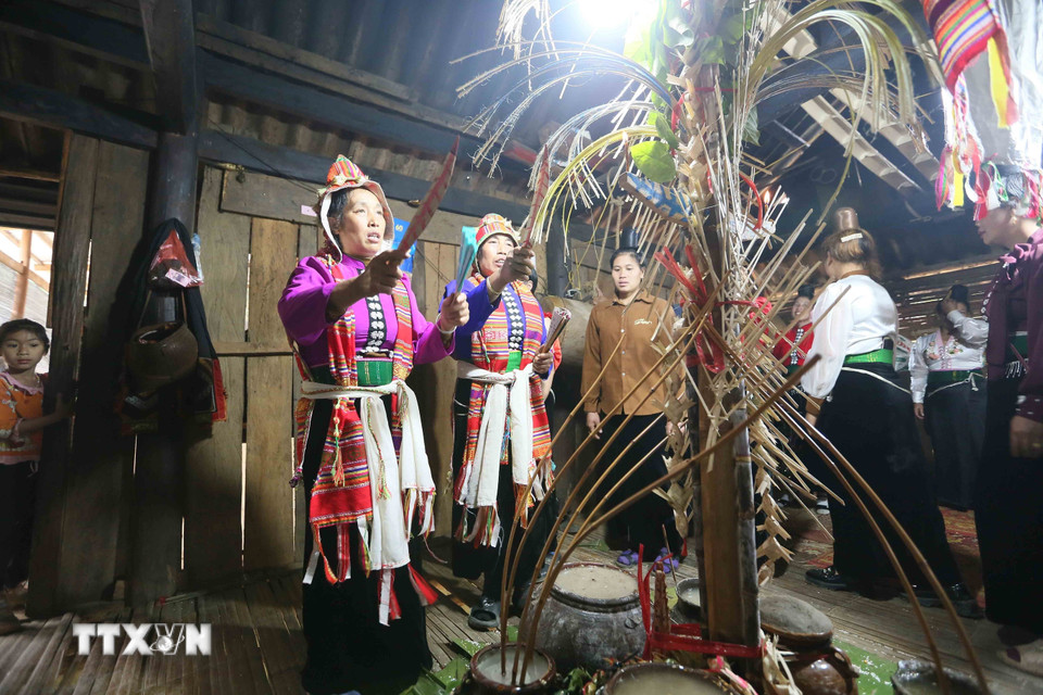 Thầy mo đỡ đầu và thầy mo được đỡ đầu (bên trái) thực hiện nghi lễ Mạng Ma. (Ảnh: Quang Quyết/TTXVN)