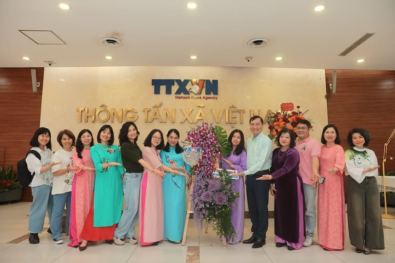 Chung vui bên tác phẩm thi cắm hoa nghệ thuật nhân dịp 8/3. (Ảnh: Vietnam+)