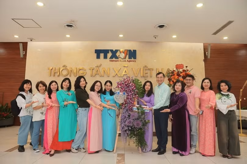 Chung vui bên tác phẩm thi cắm hoa nghệ thuật nhân dịp 8/3. (Ảnh: Vietnam+)