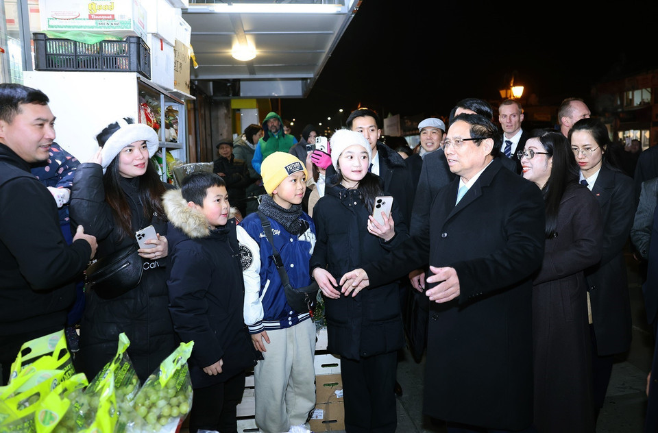 Thủ tướng Phạm Minh Chính và Phu nhân thăm cộng đồng người Việt Nam đang kinh doanh tại Trung tâm Thương mại Sapa. (Ảnh: Dương Giang/TTXVN)