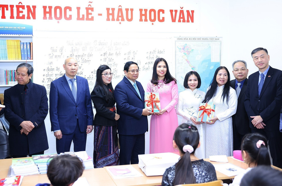 Thủ tướng Phạm Minh Chính và Phu nhân tặng sách cho lớp học Tiếng Việt tại Trung tâm Thương mại Sapa tại Thủ đô Prague. (Ảnh: Dương Giang/TTXVN)