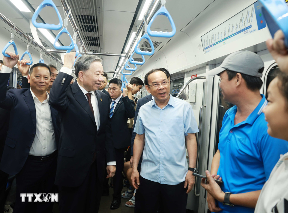 Tổng Bí thư Tô Lâm trò chuyện với người dân trên tàu. (Ảnh: Thống Nhất/TTXVN)