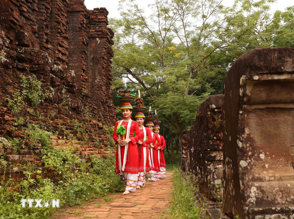 Trang phục truyền thống rực rỡ của vũ công Chăm nổi bật trên nền gạch cổ kính, tạo nên sự tương phản độc đáo. (Ảnh: Nhật Anh/TTXVN)