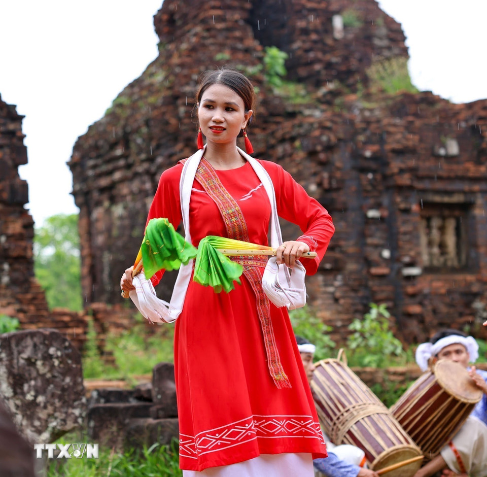 Trang phục truyền thống rực rỡ của vũ công Chăm nổi bật trên nền gạch cổ kính, tạo nên sự tương phản độc đáo. (Ảnh: Thanh Tùng/TTXVN)