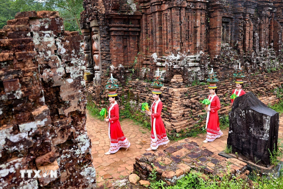 Trang phục truyền thống rực rỡ của vũ công Chăm nổi bật trên nền gạch cổ kính, tạo nên sự tương phản độc đáo. (Ảnh: Thanh Tùng/TTXVN)