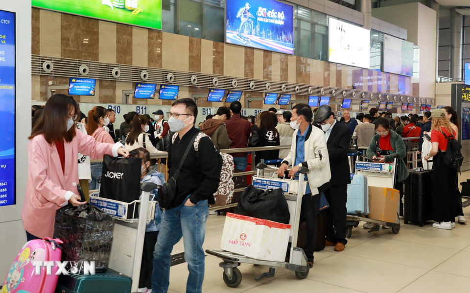 Hành khách xếp hàng chờ làm thủ tục lên máy bay về quê đón Tết tại Sân bay quốc tế Nội Bài, sáng 24/1 (25 tháng Chạp). (Ảnh: Quốc Khánh/TTXVN)