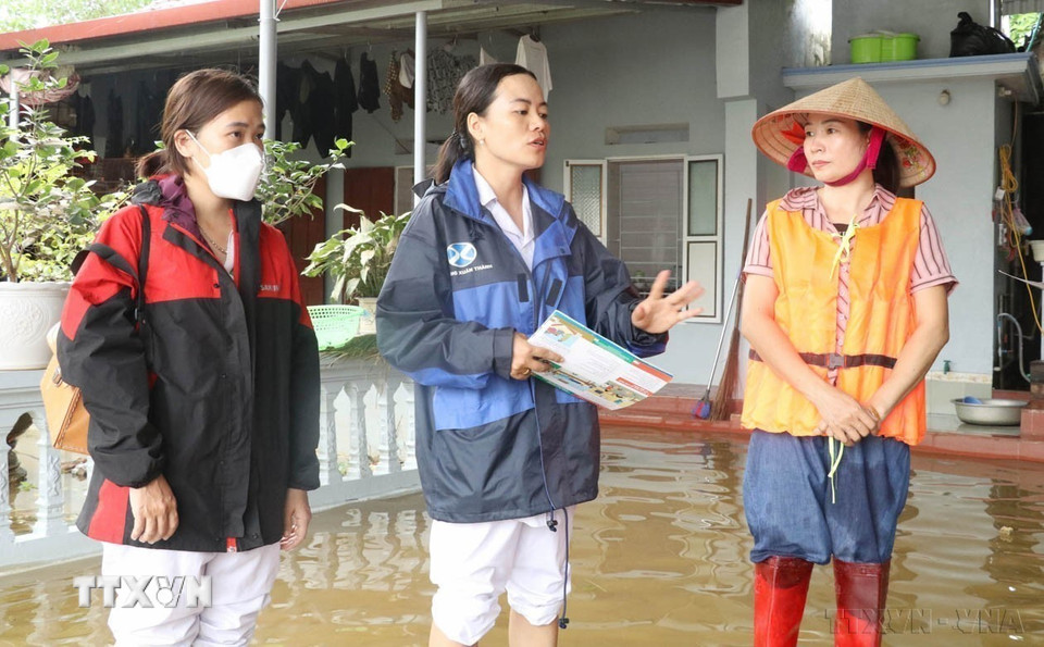 Cán bộ y tế cơ sở tuyên truyền vệ sinh môi trường cho người dân vùng ngập lụt xã Gia Thủy, huyện Nho Quan (Ninh Bình) sau khi nước rút (2024). (Ảnh: Thùy Dung/TTXVN)
