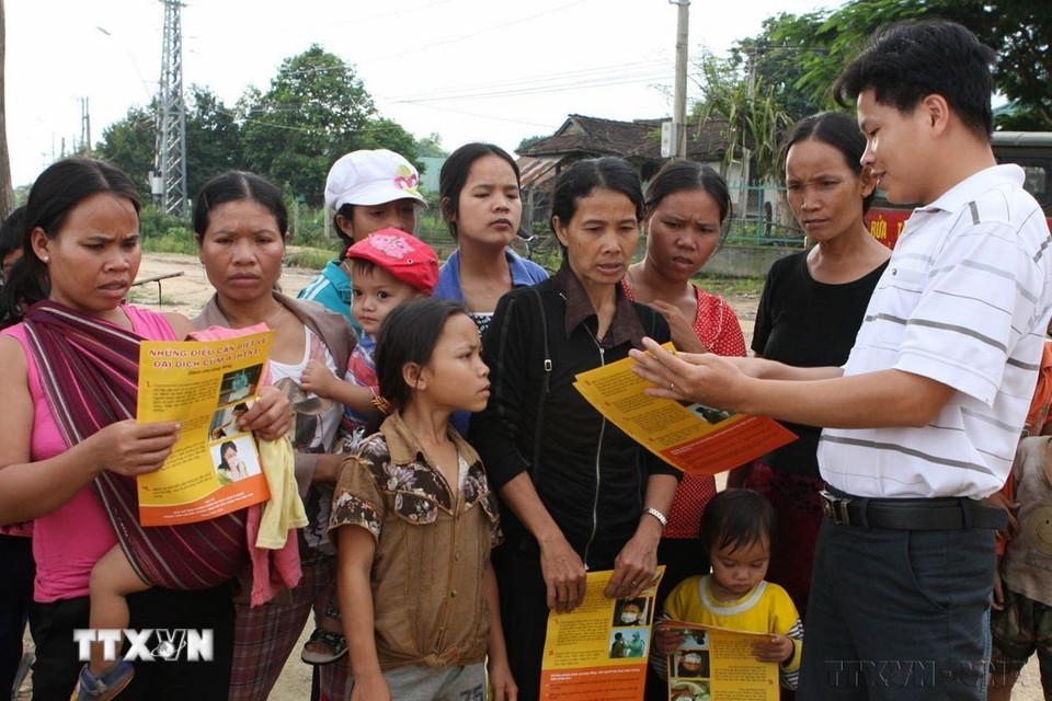 Nhân viên y tế phát tờ rơi, tuyên truyền hướng dẫn đồng bào địa phương cách phòng chống dịch cúm A (H1N1) tại các thôn, làng tỉnh Kon Tum (2009). (Ảnh: Trần Lê Lâm/TTXVN)