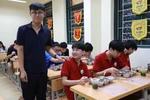 Học sinh Trường Trung học phổ thông Phan Huy Chú ăn bữa tối tại trường. (Ảnh: PV/Vietnam+)