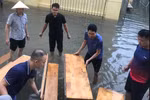Các thầy cô giáo Trường Tiểu học Nam Trung Yên đã kê bàn ghế làm cầu giúp phụ huynh đón con, học sinh không bị dầm nước. (Ảnh: PHCC)