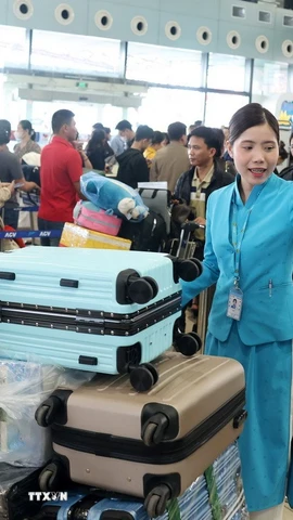 Mặc dù đông nhưng người dân, hành khách vẫn nhận được sự phục vụ, hướng dẫn nhiệt tình từ nhân viên mặt đất. (Ảnh: Quốc Khánh/TTXVN)