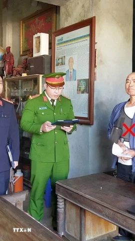 Cơ quan Cảnh sát điều tra Công an tỉnh thi hành lệnh bắt bị can Lê Minh Vũ. (Ảnh: TTXVN phát)