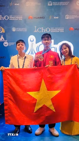 Thầy Nguyễn Đình Hùng, Hiệu trưởng Trường THPT Chuyên Vĩnh Phúc cùng cô giáo Phùng Thị Nga, giáo viên trực tiếp phụ trách đội tuyển và em Đinh Xuân Phúc tại Lễ trao giải Kỳ thi Olympic Hóa học Quốc tế năm 2026, diễn ra tại Uzbekistan. (Ảnh: TTXVN phát)