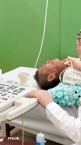 Bác sỹ Tôn Thanh Trà, Giám đốc Bệnh viện Chợ Rẫy - Phnom Penh trực tiếp thăm khám, siêu âm một trường hợp bệnh nhân bệnh nặng, tiếp nhận phẫu thuật miễn phí tại bệnh viện. (Ảnh: Quang Anh/TTXVN)