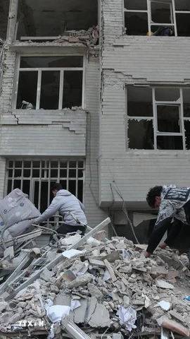 Người dân tìm kiếm đồ đạc trong đống đổ nát của những tòa nhà bị phá hủy sau các cuộc tấn công tại Tehran, Iran, ngày 12/3/2026. (Ảnh: THX/TTXVN)