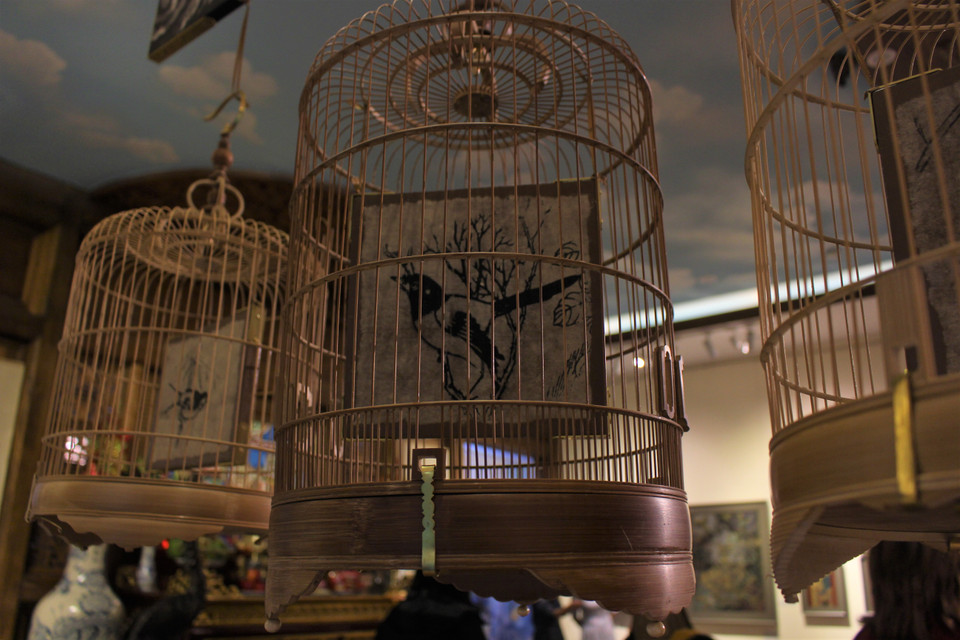 'Lồng chim' và Sách sơn mài là hai tác phẩm sơn mài sắp đặt. Trong đó, 'Lồng chim' gửi đi thông điệp về số phận của những sản phẩm truyền thống dường như đang bị gò bó trong cuộc sống hiện đại ngày nay. (Ảnh: Minh Anh/Vietnam+) 
