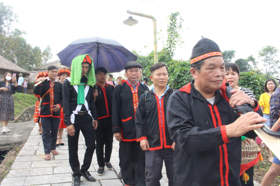 Khi đi trên đường, chú rể được che trên đầu một chiếc ô đen để tránh ma quỷ, mọi sự xui xẻo, người đóng vai quan làng cho biết. (Ảnh: Minh Anh/Vietnam+)