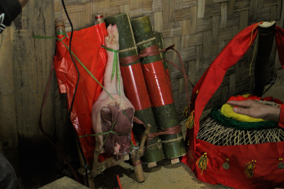 Lễ vật gồm 36 đồng bạc đựng trong chiếc túi đỏ nhỏ, buộc dây màu vàng, rượu được đựng trong ống nứa (giờ đây họ còn đựng trong chai), 2 con gà trống, thịt lợn, hoa quả bánh kẹo, lồng gà được trang trí hoa giấy sặc sỡ. (Ảnh: Minh Anh/Vietnam+)