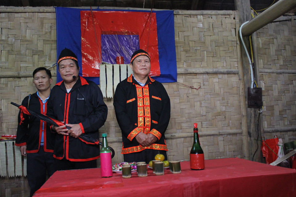 Lễ tái hiện bắt đầu bằng cảnh ở nhà trai. Trước khi đi đón dâu, chủ nhà trai (bên phải) tập hợp mọi người lại để giao nhiệm vụ cho quan làng (giữa), phó quan làng (trái) và các thành viên của đoàn đi đón dâu. Sau khi bàn giao lễ vật cho quan làng, chủ nhà mời mỗi người 1 chén rượu rồi trao trách nhiệm đón dâu. Quan làng nhận nhiệm vụ và hứa với chủ nhà trai sẽ đưa cô dâu về nhà an toàn, đi đến nơi về đến chốn, thuận lợi. (Ảnh: Minh Anh/Vietnam+)